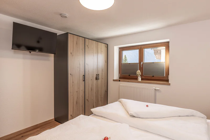 Schlafzimmer mit Doppelbett, Kleiderschrank und Flat-TV