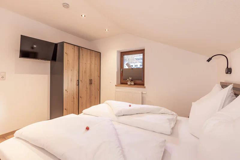 Schlafzimmer mit Kleiderschrank, Flat-TV und Fenster