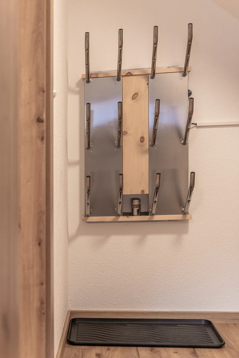 Der Schuhtrockner an der Wand, darunter eine Abtropfschale