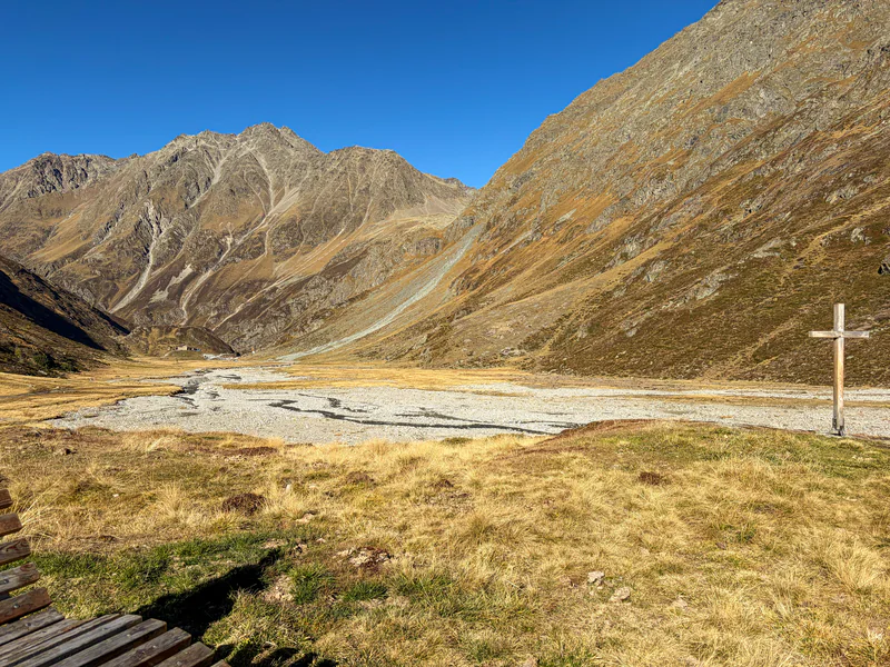Karges Hochtal mit breitem Gletscherbett und Holzkreuz
