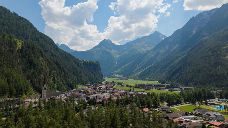 Längenfeld im Sommer: das Dorf mit dem Kirchturm vor den Bergen