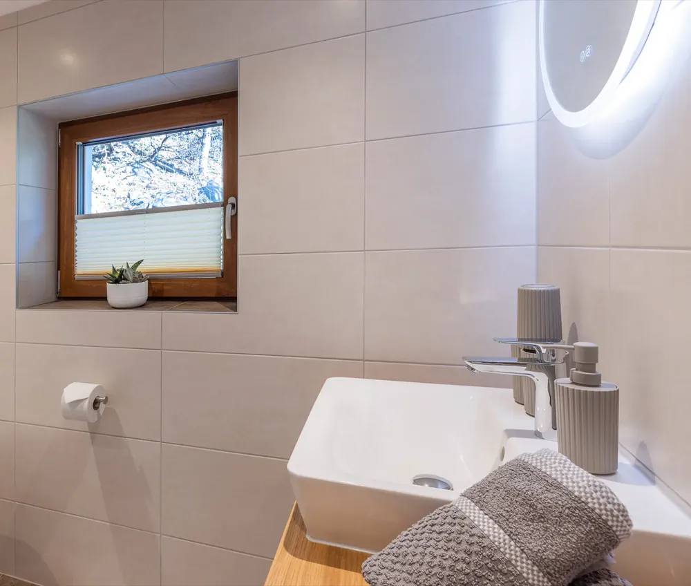 Bad im Erdgeschoss: Waschtisch und Fensternische mit Pflanze